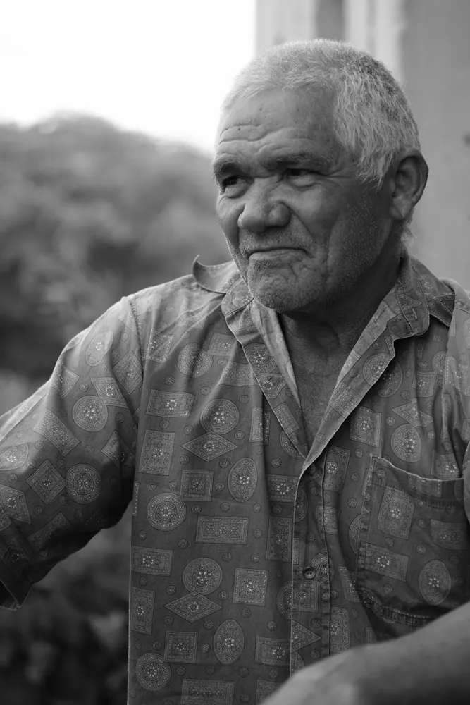 Retrato de um senhor da comunidade em preto e branco.