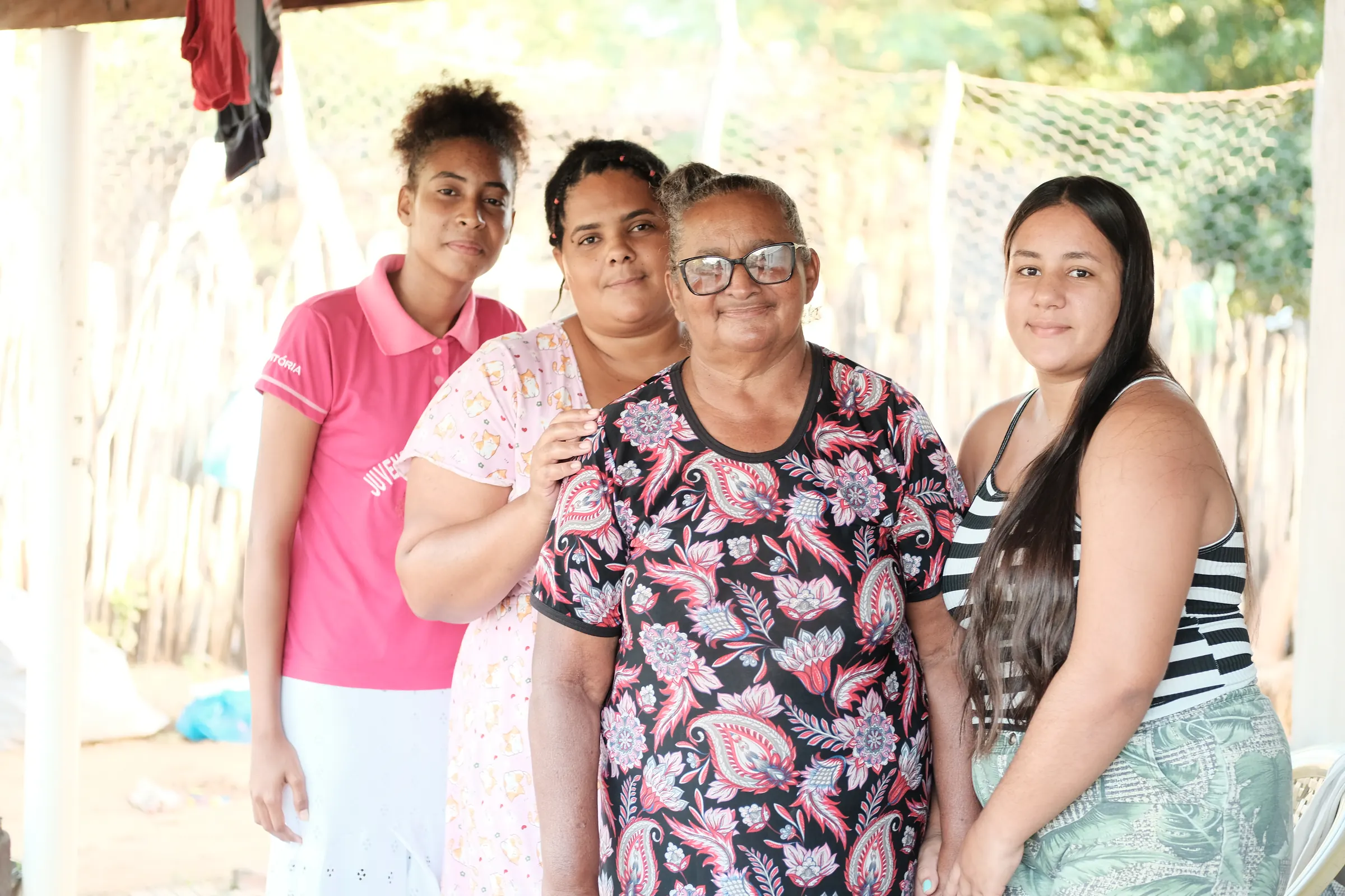 Quatro mulheres de gerações diferentes da Varzinha dos Quilombolas, abraçadas.
